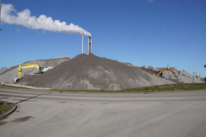 A pile of bottom ash near an industrial area