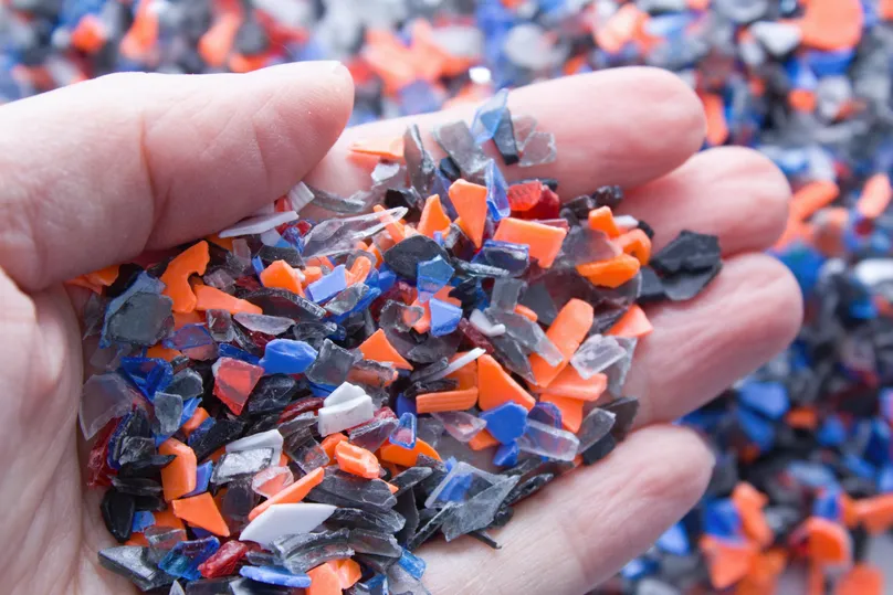Open hand holding recycled plastic chips