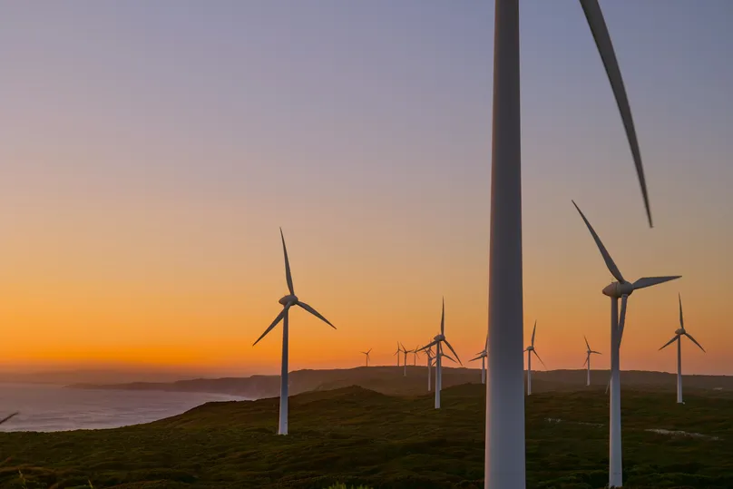 Coastal wind farm scene at sunset