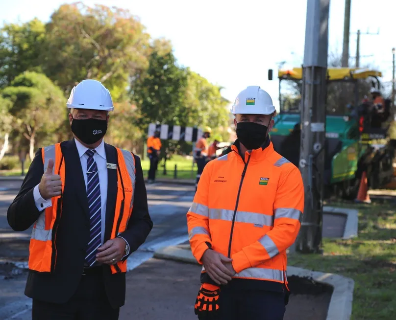 Photo of the City of Canning mayor and road works manager, wearing black mask and white safety helmet
